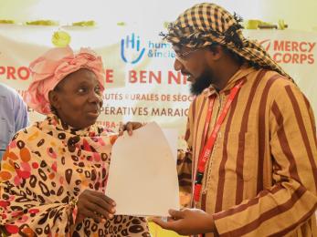 Participants at a ben ni baara event holding a document.