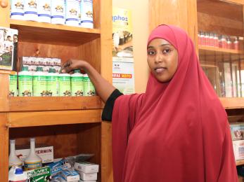 Woman from horn of africa displays some products in her agrovet shop.
