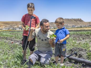 Father and sons engaging and smiling in the middle of their farm.