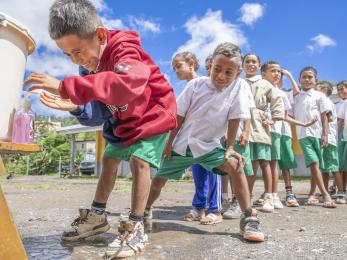 Children line up to wash their hands before eating lunch at school in maubisse villa, timor-leste.