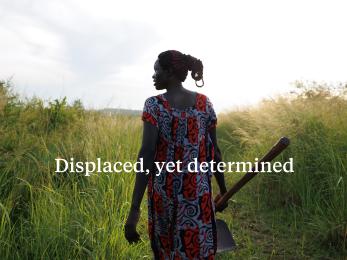 Silhouette of ugandan woman walking through field.