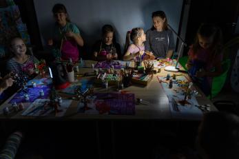 A family attends an art therapy session during a blackout.