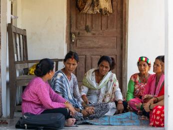 Nepalese community members sit in discussion.