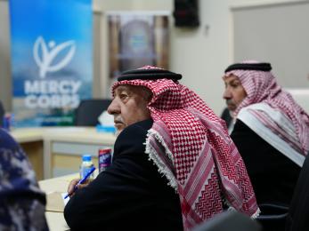 Men listening to a speaker at a conference.