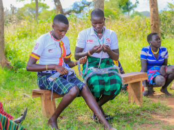 Young women sit on benches working together on program material.